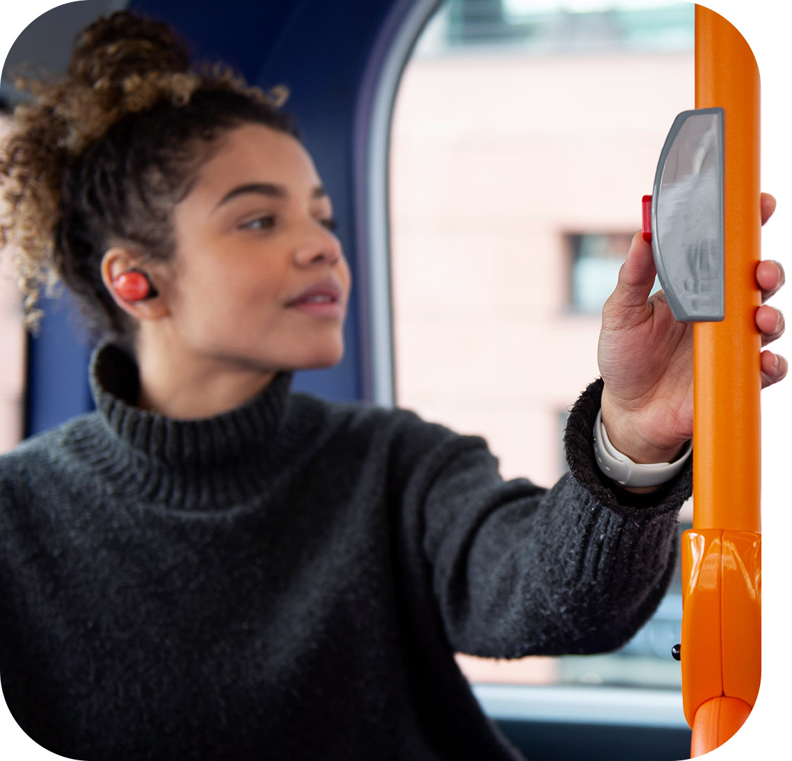 Mulher apertando botão de pedido de parada em ônibus